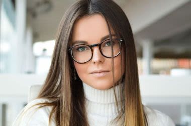 Young woman in sweater and glasses