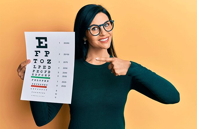 woman holding up a Snellen eye chart