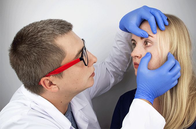 eye doctor inspecting patient's eye with corneal disease