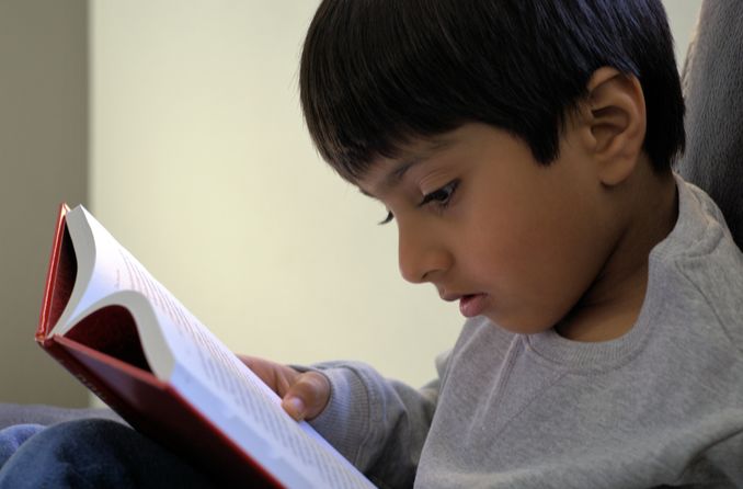 A young boy reads a book