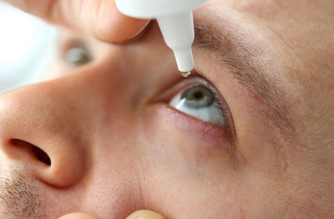 Man using eye drops