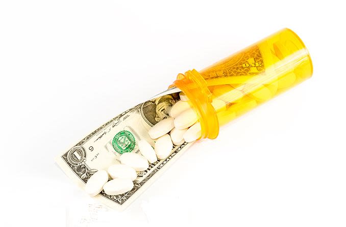 Prescription bottle with bills and dollar bill