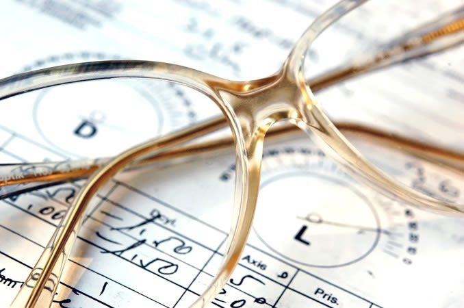 A pair of eyeglasses laying over the top of an eyeglasses prescription.