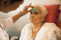 一位年长的印度妇女正在接受眼科医生给她的眼睛滴眼药水。