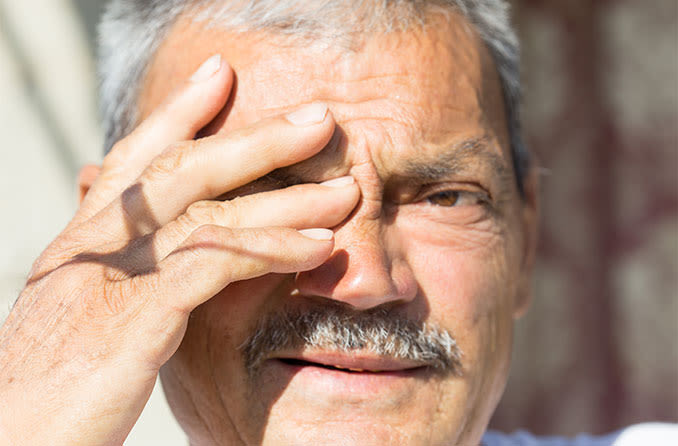 uomo sensibile alla luce intensa, che è un sintomo di cataratta