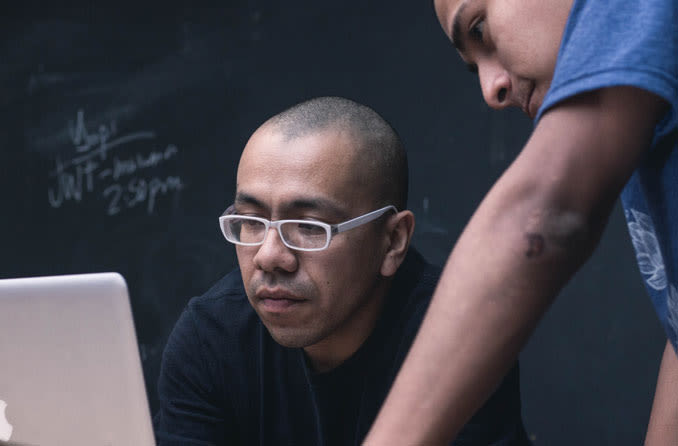 man looking at laptop wearing trendy eyeglasses