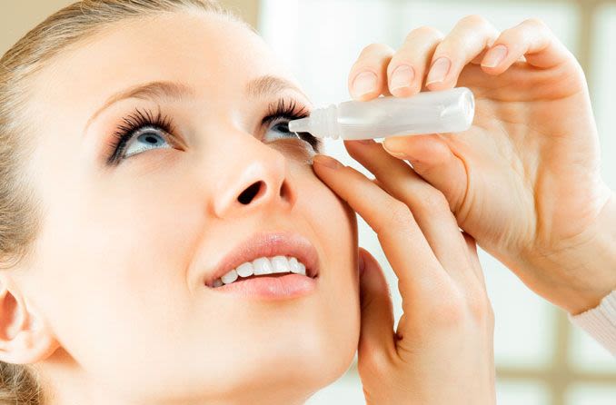 Woman using eye drops properly.