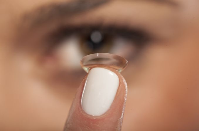 mujer insertando lentes de contacto