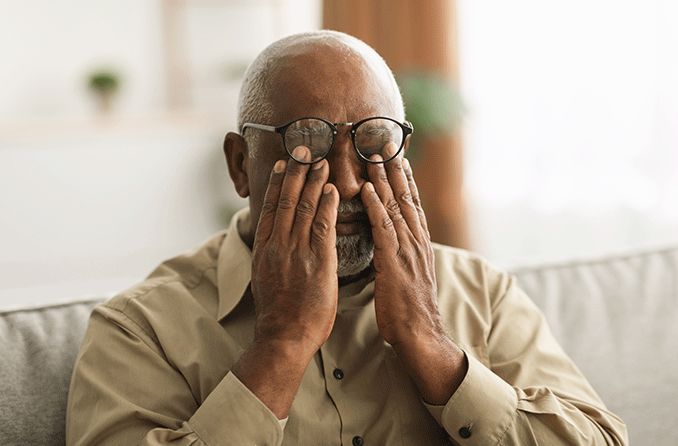 Older man who is a glaucoma suspect rubbing his eyes