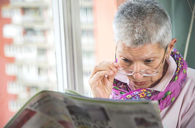 senior woman with low vision having difficulty reading