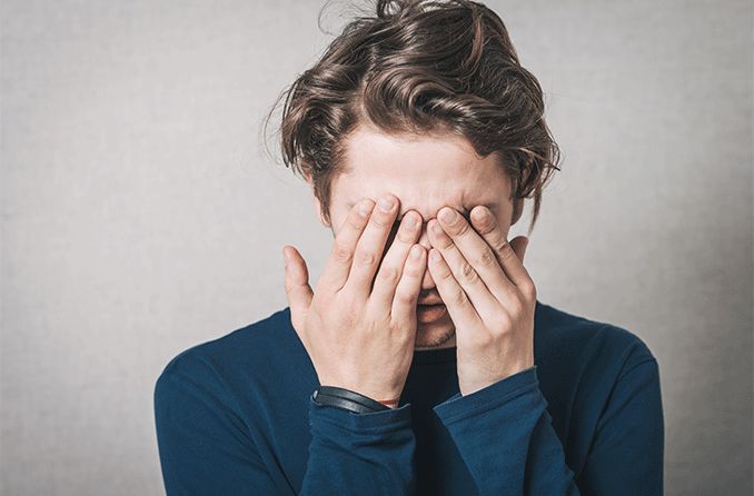 person covering eyes with hands who has staph infection in eyes