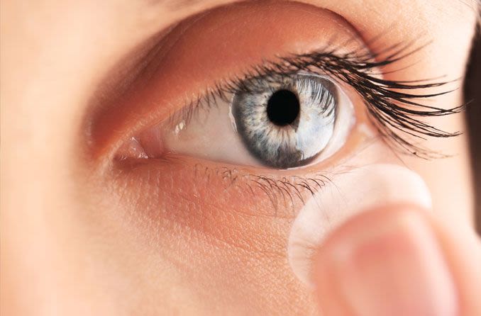 Woman inserting contact lenses to control myopia