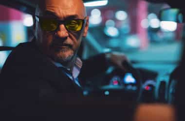 Pria yang memakai kacamata mengemudi malam saat mengemudi