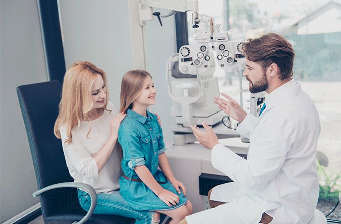 parent asking questions to child's eye doctor
