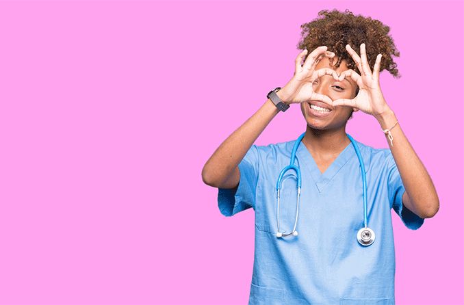 doctor holding up fingers to her eye in the shape of a heart 