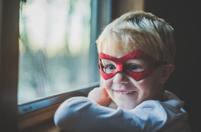 enfant heureux portant un masque de super-héros