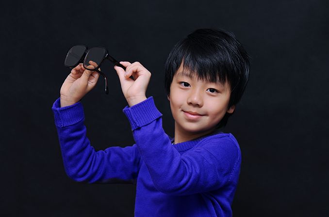 young boy trying on a pair of eyeglasses