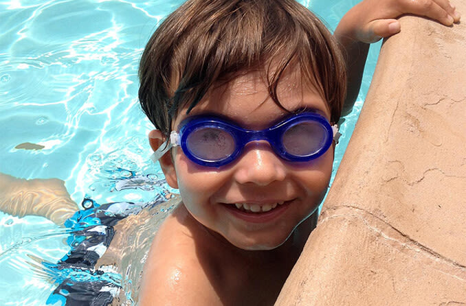 child wearing swim goggles in pool