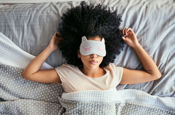 woman in bed wearing a sleep mask