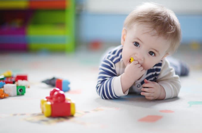 bébé sur le sol jouant avec des jouets