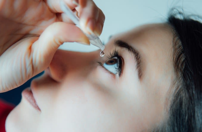 Una niña usa gotas para los ojos para aliviar las alergias