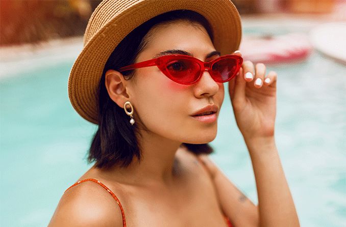 woman in a pool wearing red sunglasses