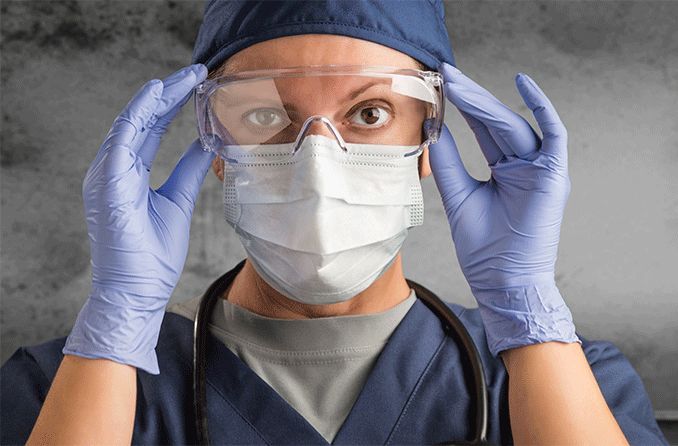 doctor wearing face mask, gloves and goggles protecting from covid