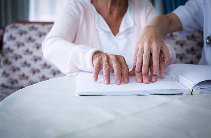 older person reading braille