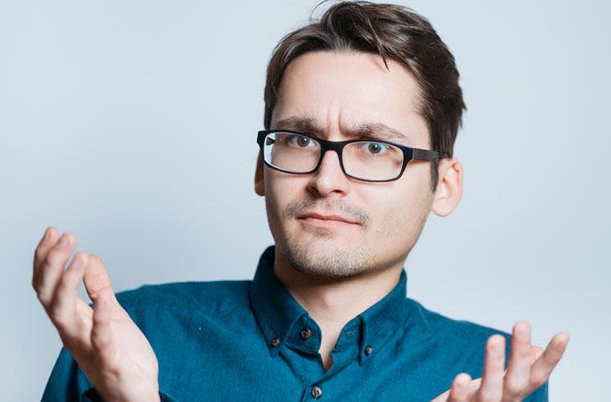 Puzzled man in blue shirt and glasses