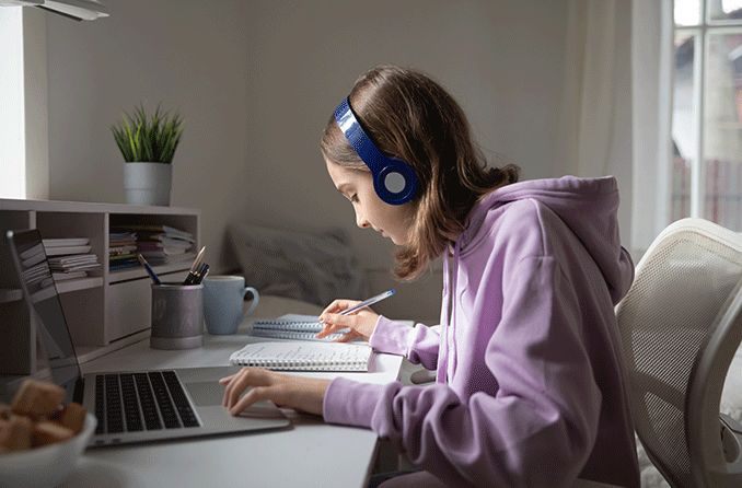 teenage girl doing homework online during covid lockdown