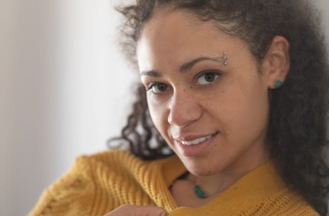 Young woman with barbell eyebrow piercing.