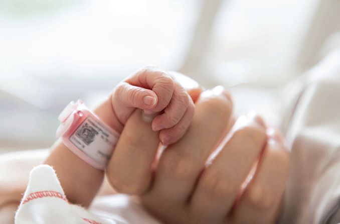 premature baby holding mother's hand