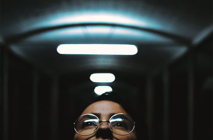 Hombre de mediana edad con lentes progresivos mirando las luces navideñas