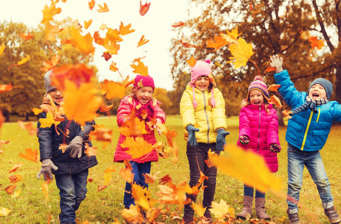 kids playing in autumn leaves