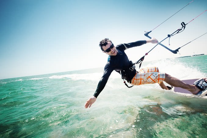 Personne portant des lunettes de soleil en parachute ascensionnel sur l'océan