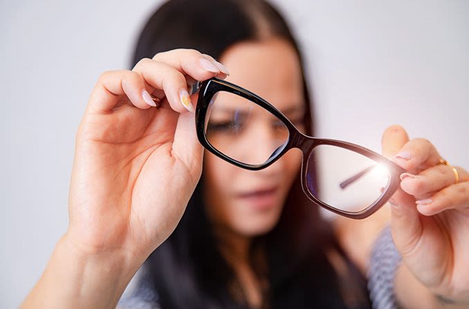 woman looking through a pair of eyeglasses
