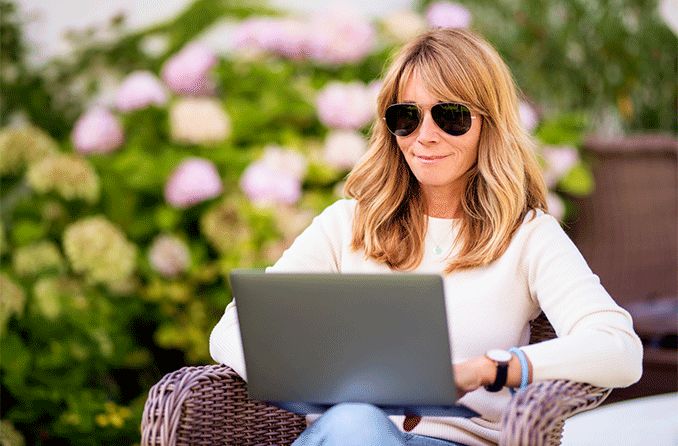 woman wearing bifocal sunglasses looking at laptop computer