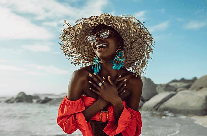 woman on the beach wearing a sunglasses and a hat