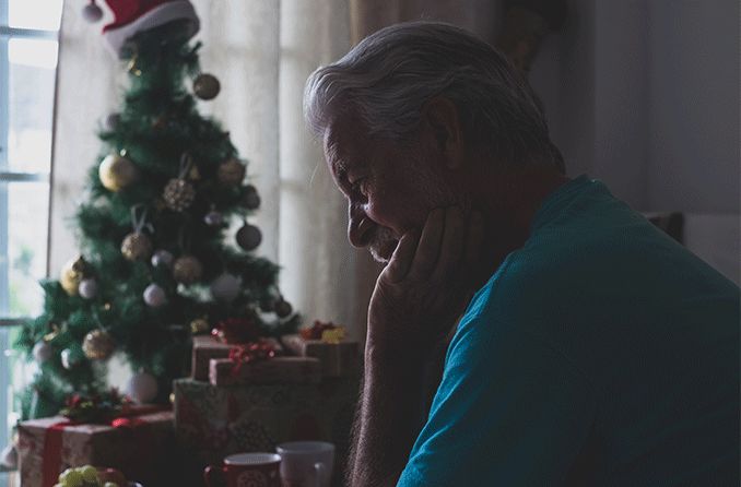man with cataracts next to christmas tree