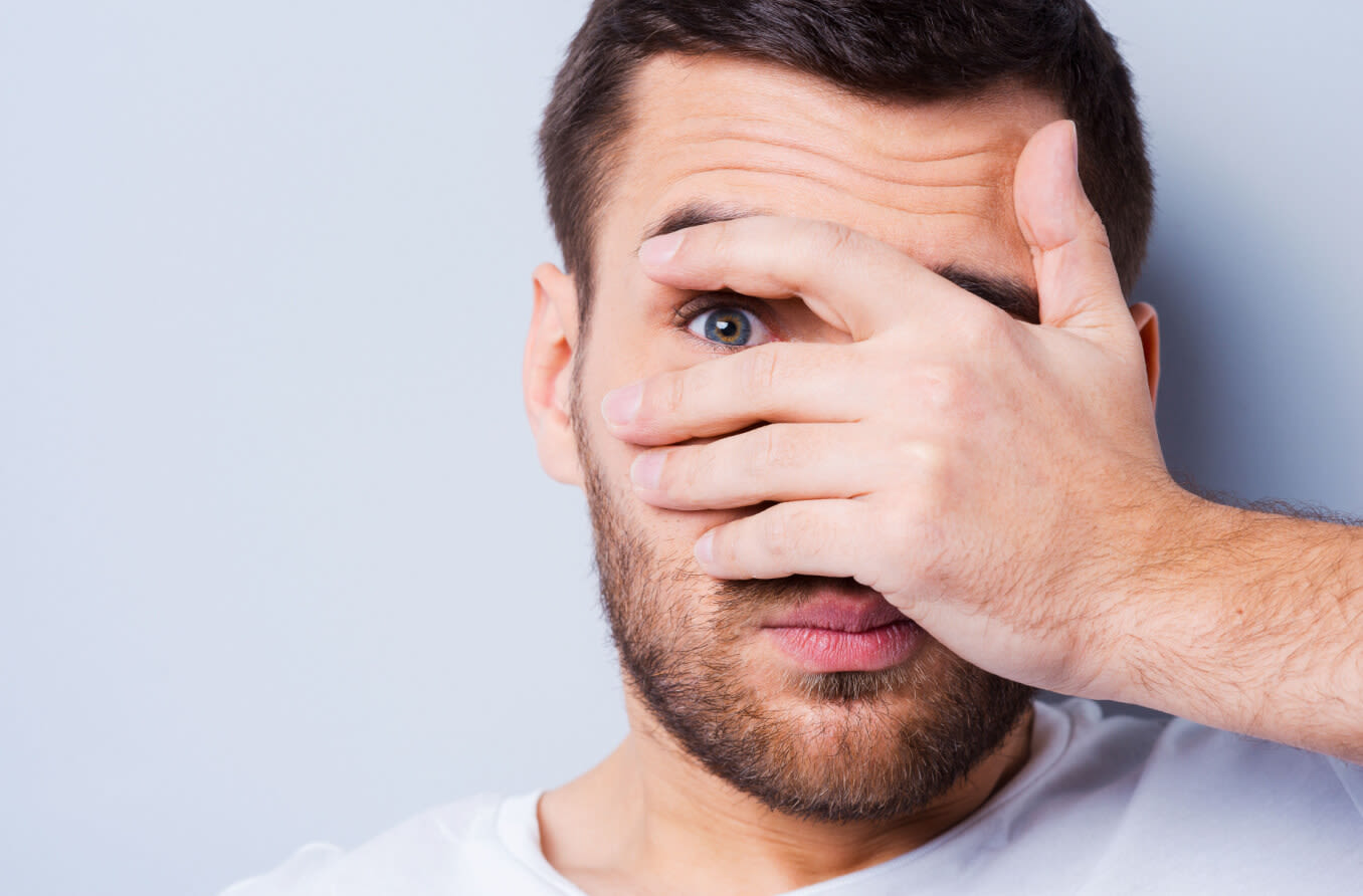 Mujer cubriendo sus ojos debido a la fotofobia