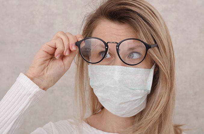 woman wearing face mask looking through her anti-fog glasses