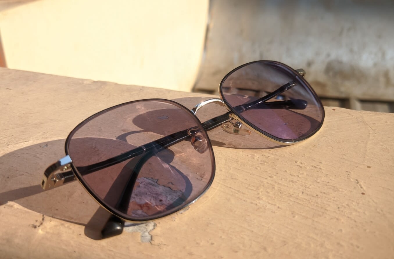 Transitions lenses outdoors on a beige background.