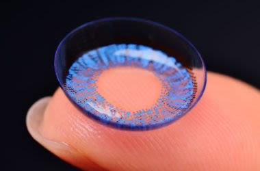 Finger displaying contact lens with color change lens