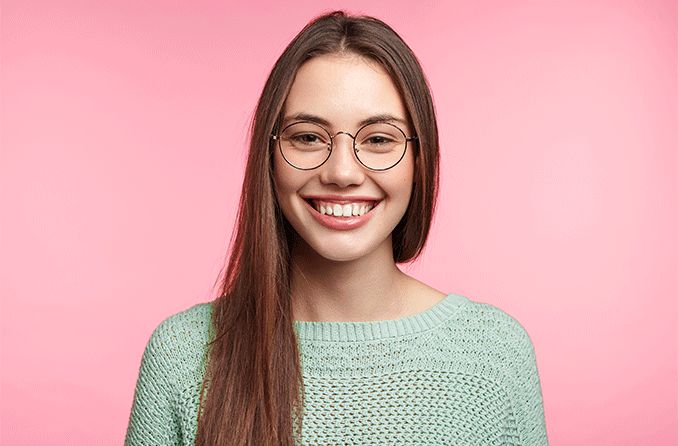 woman wearing circle glasses on pink background