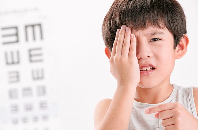 child getting a vision screening covering one eye