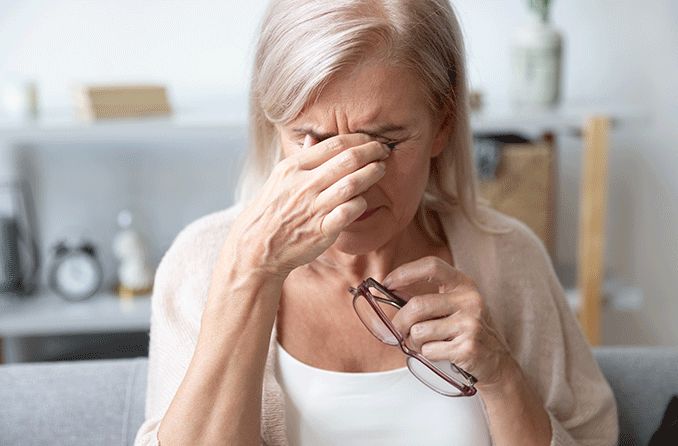 woman with degenerative myopia (or pathological myopia) pinching bridge of nose