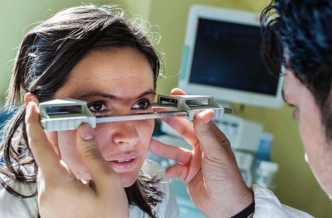 woman getting measured for bulging eyes by an eye doctor