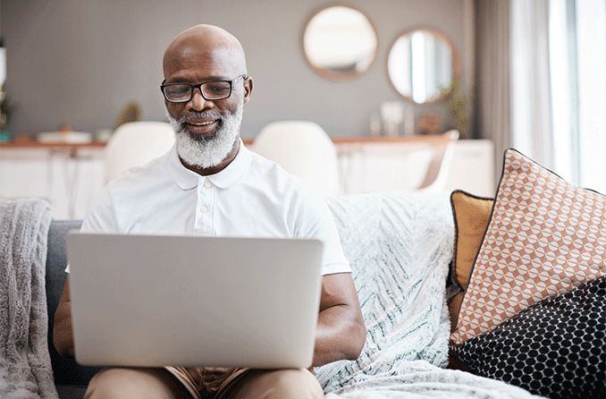 man wearing glasses looking at laptop shopping on GlassesUSA