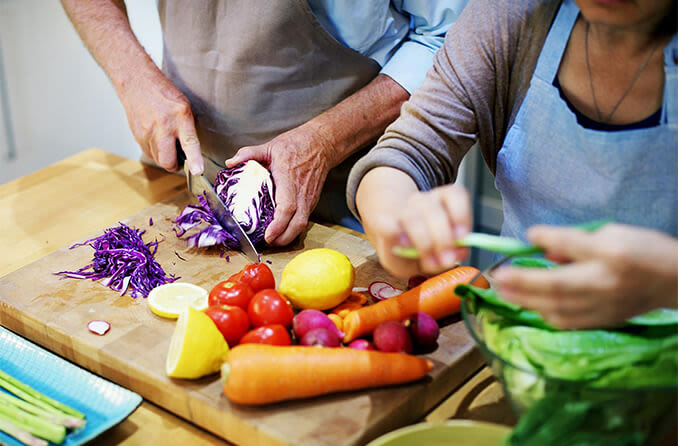 elderly couple making salad