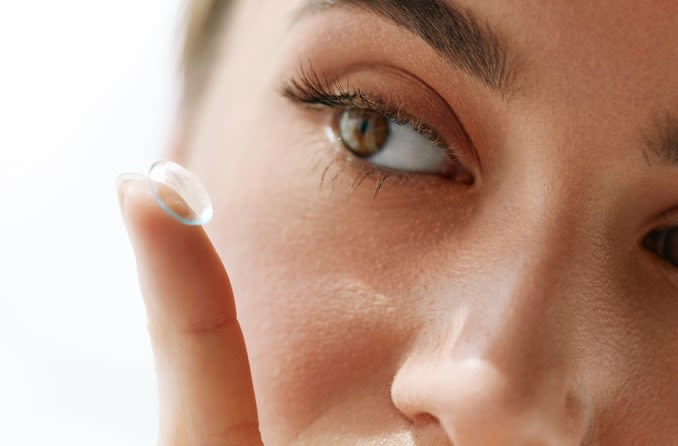 Woman putting on contact lens